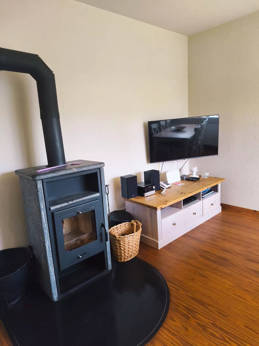Ferienhaus Deichsonne – Wohnzimmer mit Kaminofen und Fernsehecke