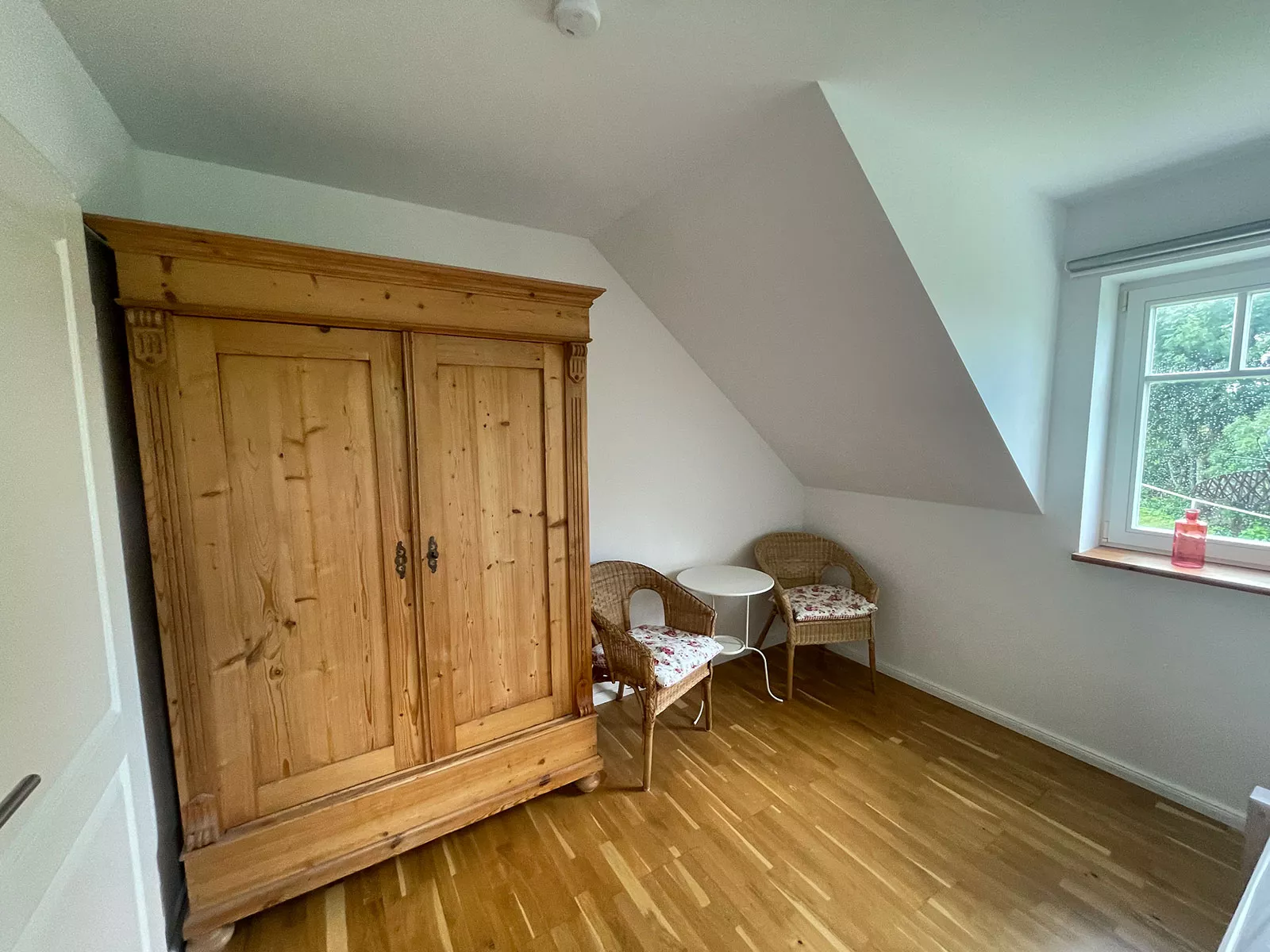 Ferienhaus Deichstern – Kleiderschrank und Sitzgelegenheit im ersten Schlafzimmer