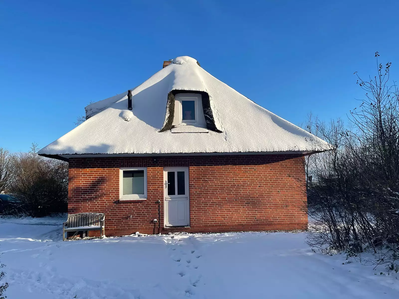 Ferienhaus Deichsonne mit Reetdach im Winter, leicht mit Schnee bedeckt